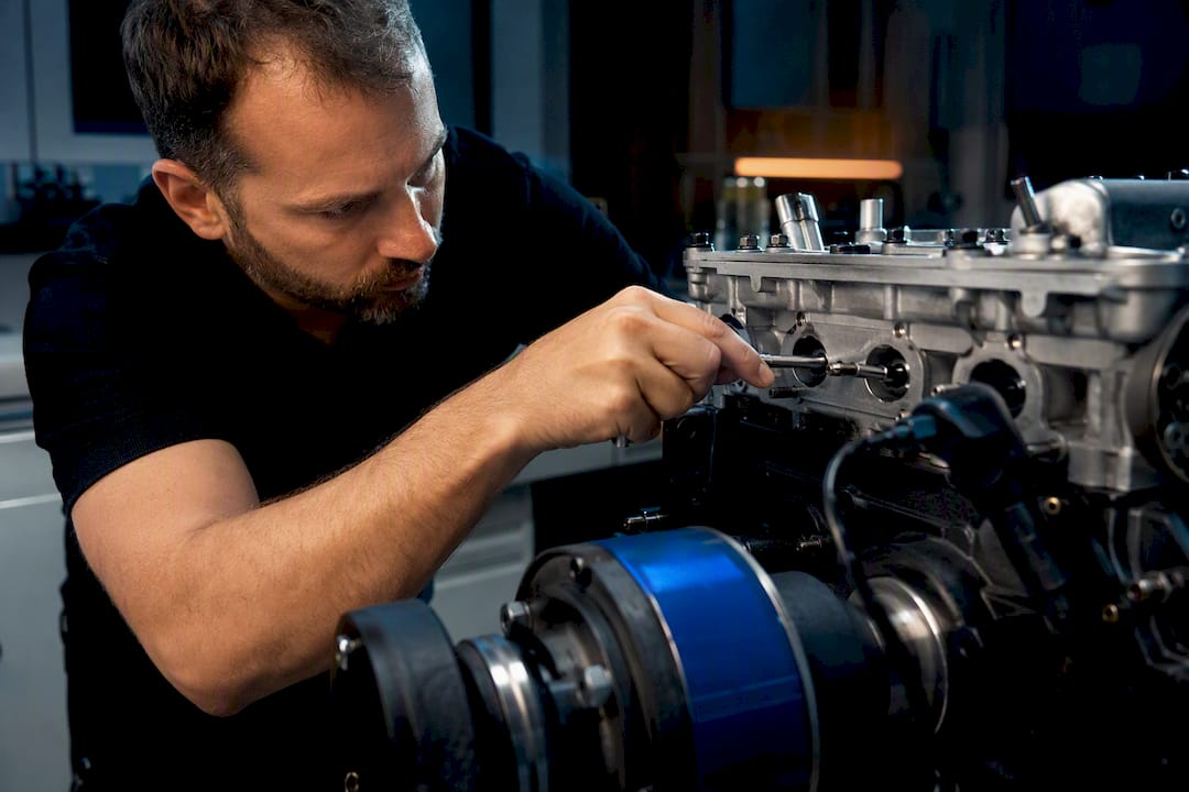 Spark Advance Tuning: A Practical Guide To Mbt And Knock Limits Technician Adjusting Spark Timing On Engine Fixture