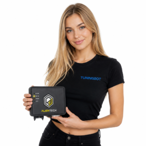 Blonde woman with light eyes wearing a black embroidered TUNINGBOT t-shirt, holding an original Alientech KESS3 interface in her hands, photographed on a clean white studio background.